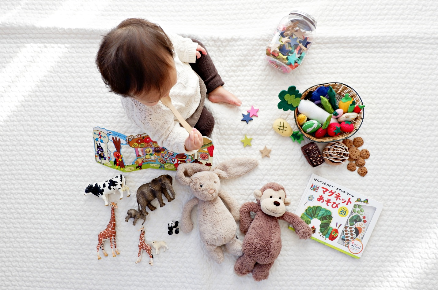baby surrounded by a variety of toys